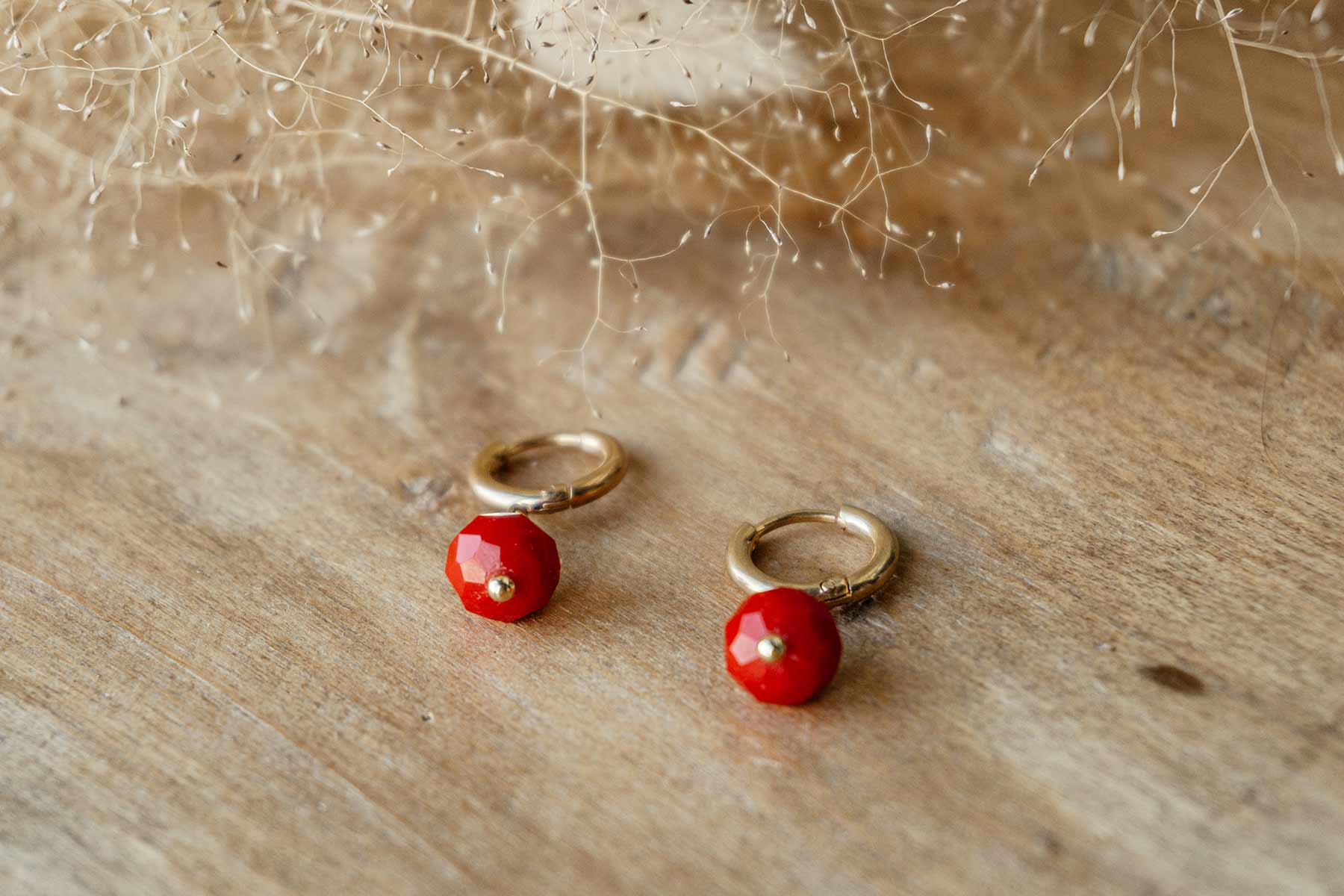Aros dorados de 12 mm con cristal facetado rojo