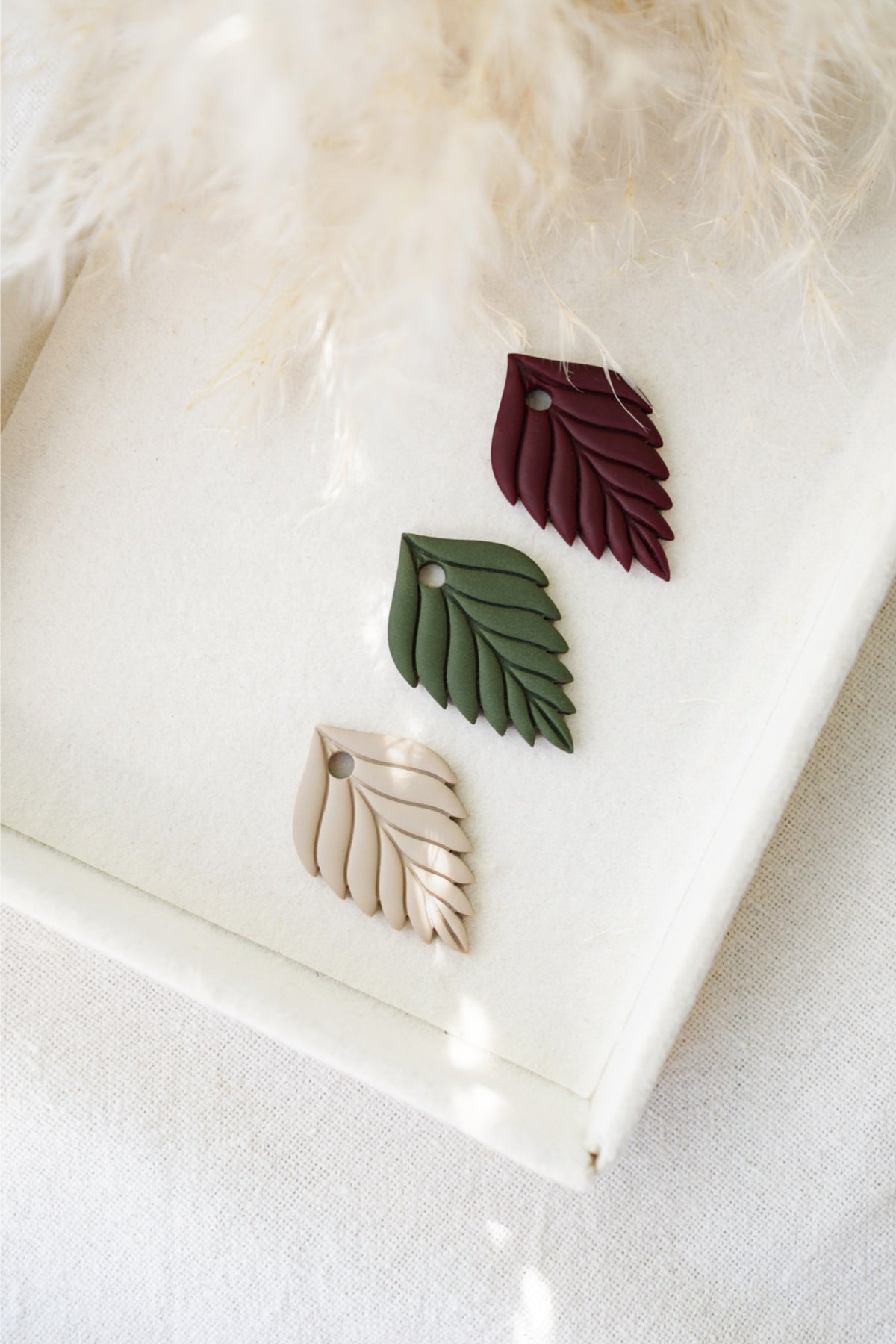Charm con forma de hoja en colores otoñales: arena, verde militar, burdeos