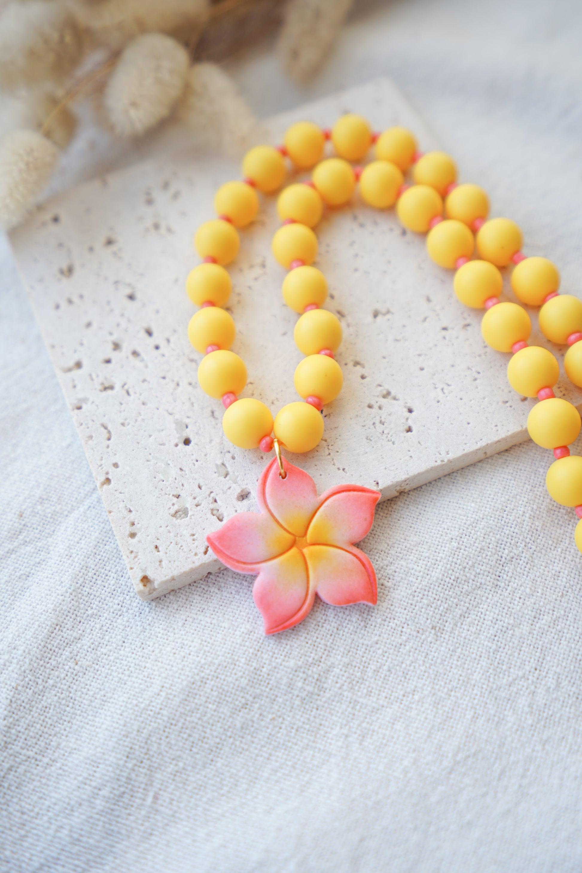 Collar de bolas de color amarillo y coral