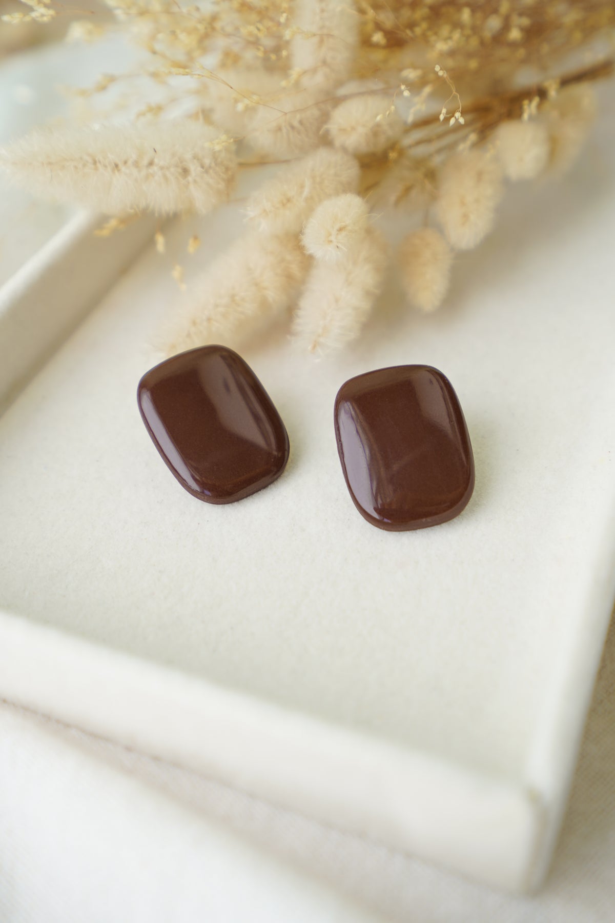 Pendientes Inverness de arcilla polimérica hechos a mano en Galicia, diseño rectangular con esquinas redondeadas y resina brillante en color marrón chocolate