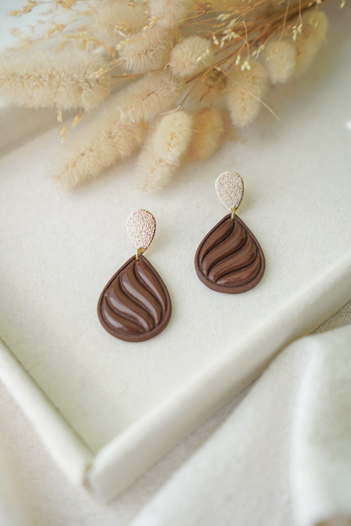 Pendientes Stirling de arcilla polimérica hechos a mano en Galicia, diseño en forma de lágrima con ondas de resina en color marrón chocolate